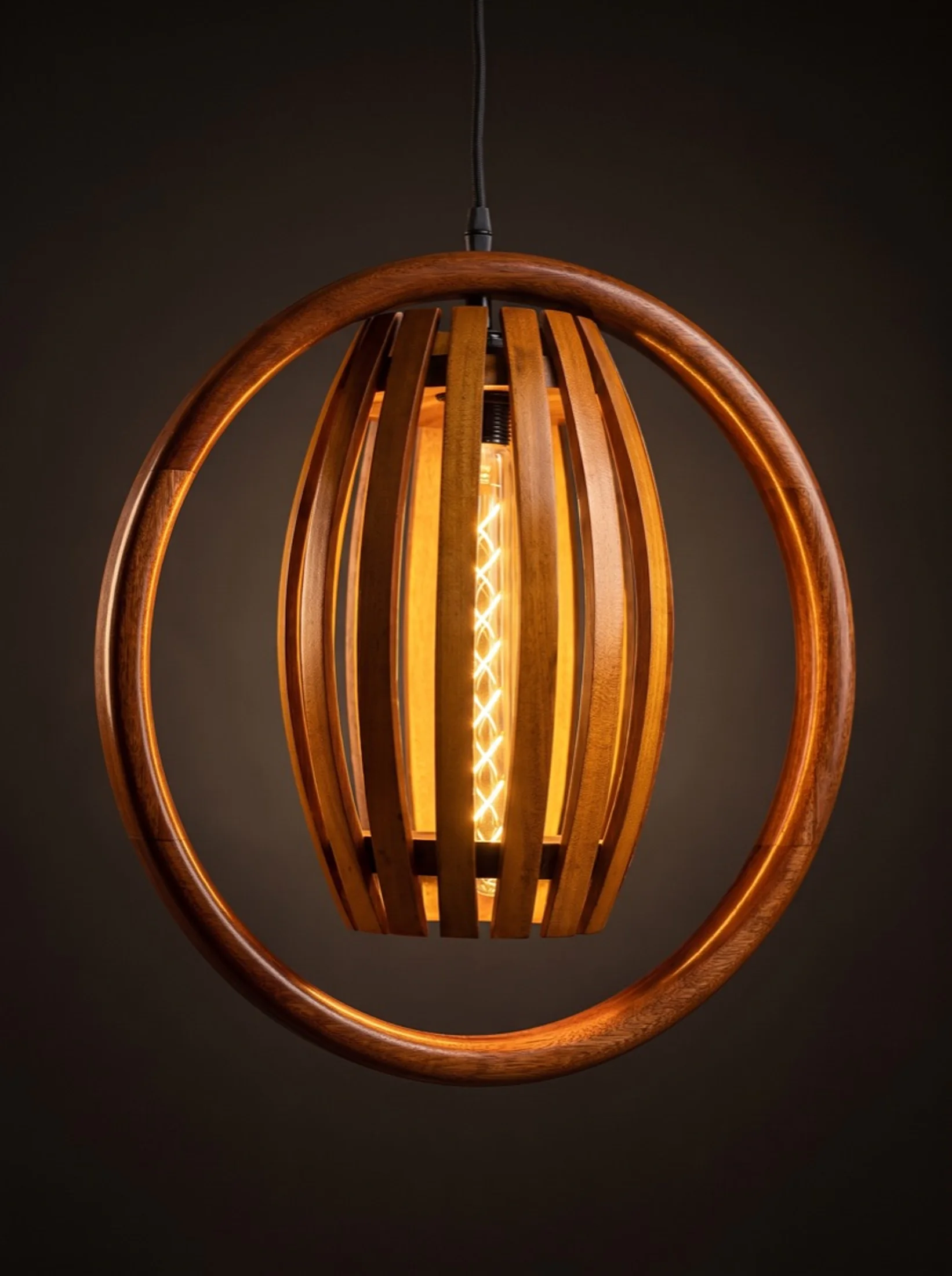A halo pendant lit, its globe glowing inside the carved ring